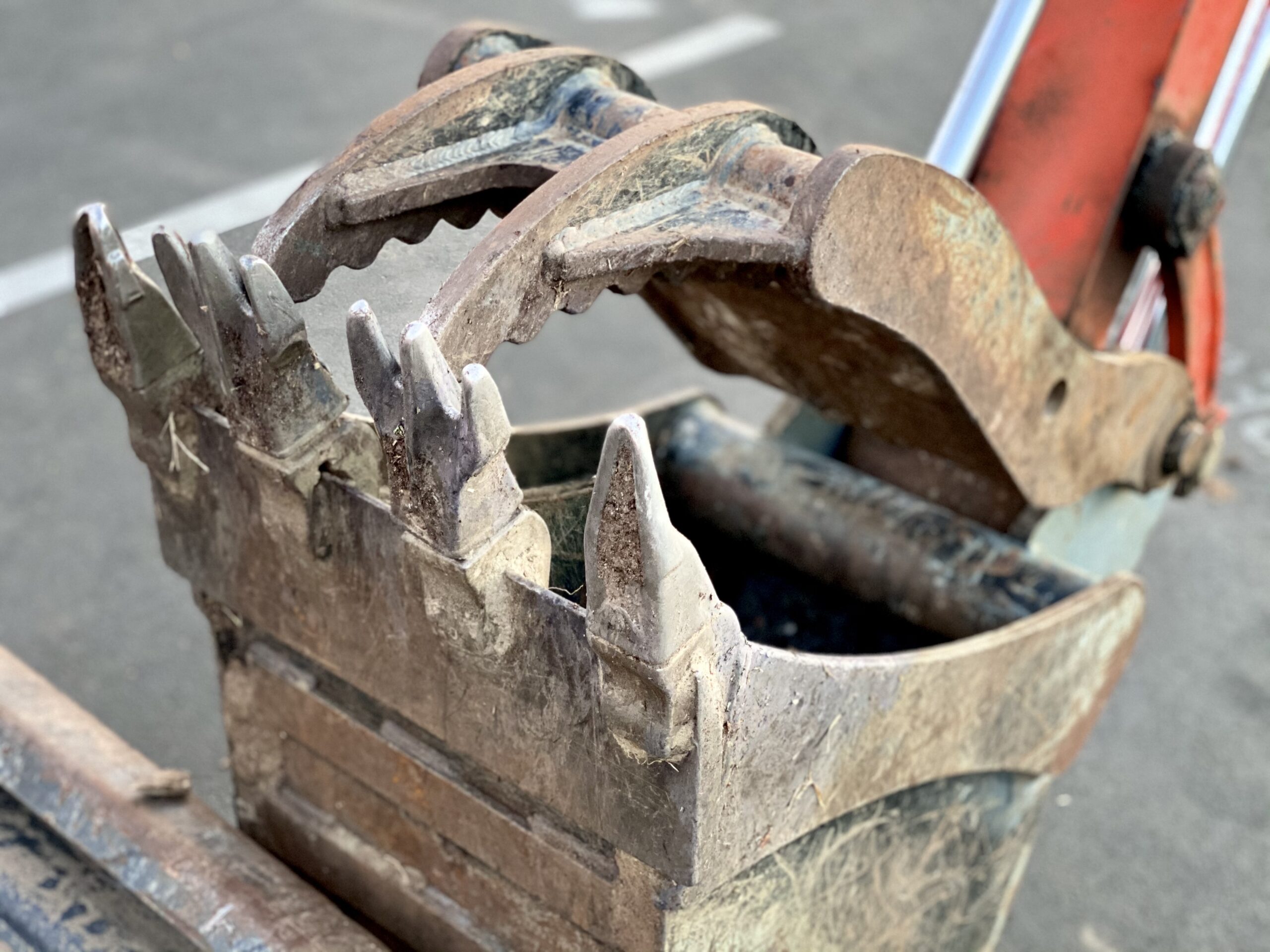 Łyżka krusząca kruszy beton na placu budowy